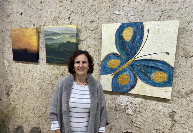 Manuela Widmer mit drei ihrer Bilder. Der Schmetterling entstand in ihrem Malkurs im Piemont und wurde zum Sinnbild für den Start ihrer Malkarriere. Foto: Sonja Fasler