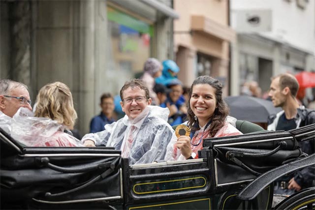 Olympiasiegerin Chiara Leone präsentiert trotz Regenwetters strahlend ihre Goldmedaille. Neben ihr links Bundesrat Albert Rösti. Foto: ssv