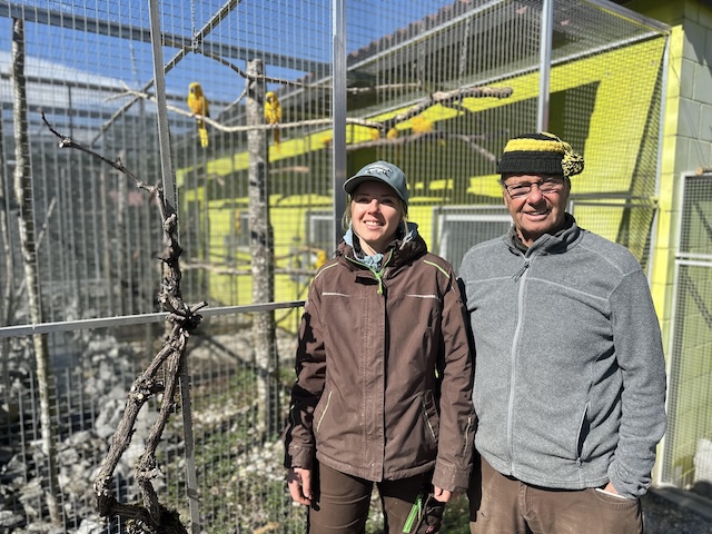 Noemi Appert und Rolf Lanz vor der Voliere der Goldsittiche, eine bedrohte Art, die aus Südamerika stammt, und im Rahmen des Artenschutzprogramms im Vogelpark gezüchtet wird. Foto: Sonja Fasler