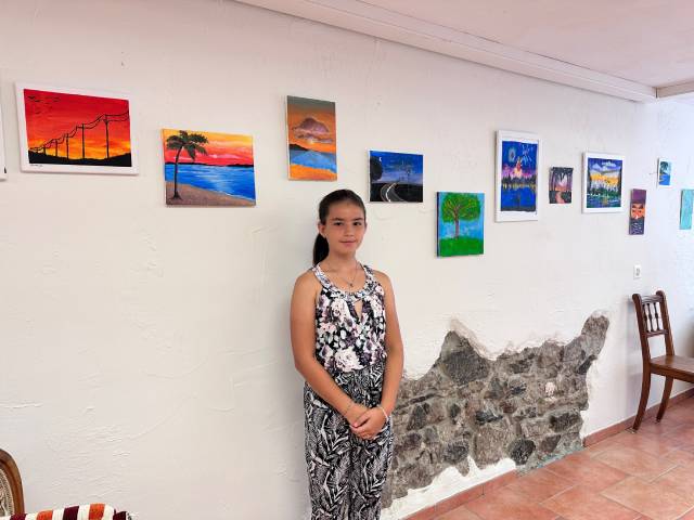 Laura zwischen ihren Bildern in der Galerie